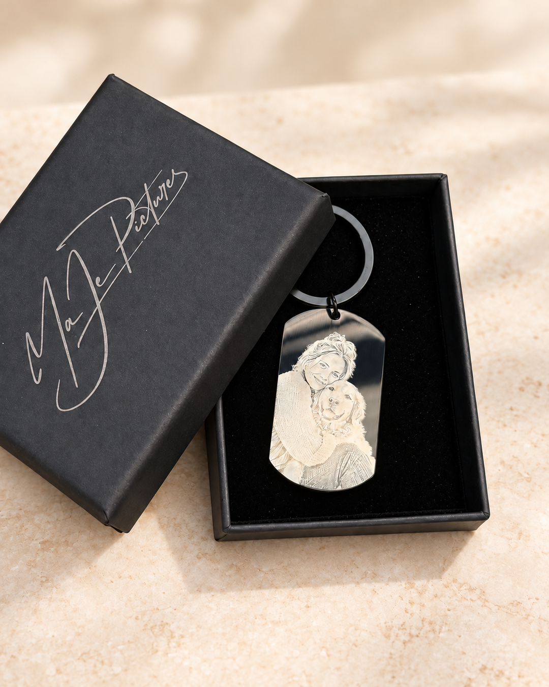 Digital gestaltete Studioansicht auf Basis der Originalaufnahme IMG_9650: Edelstahl-Foto-Dogtag mit Schlüsselring in der optionalen großen MaJe-Geschenkschachtel; Hintergrund digital gestaltet